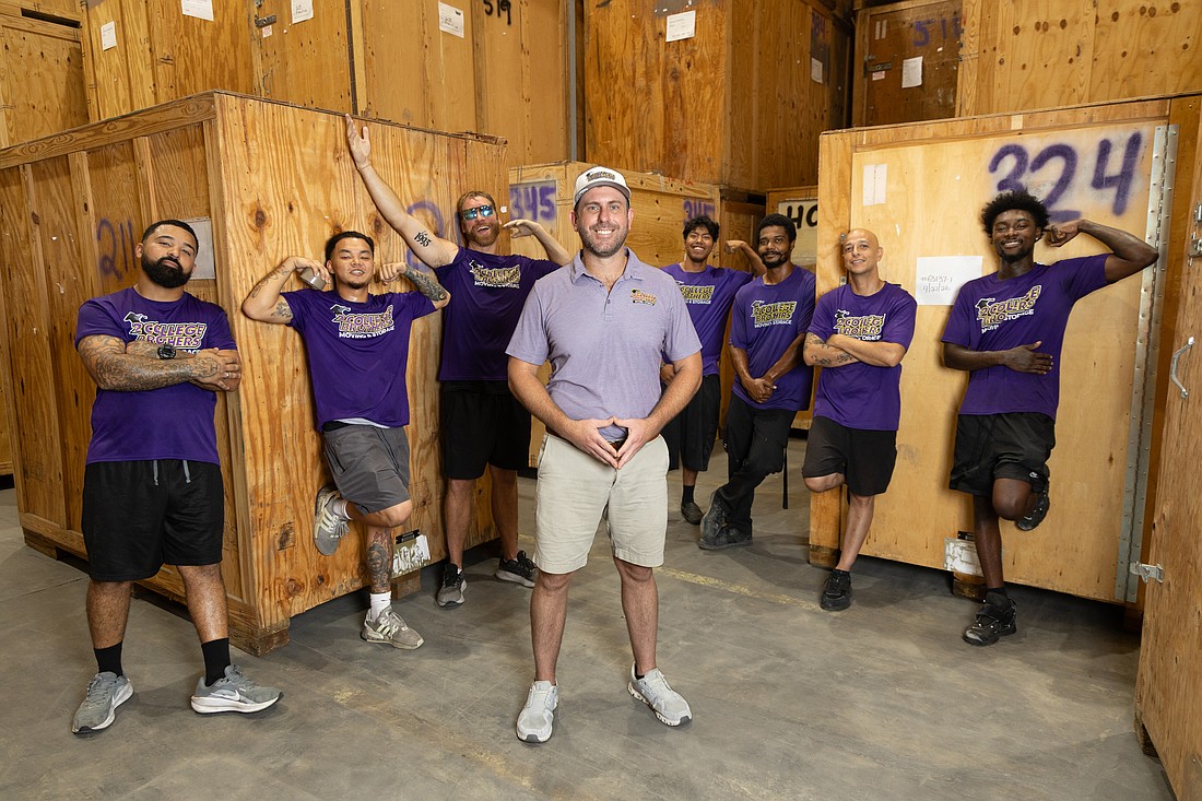 Wade Swikle, CEO of 2 College Brothers Moving and Storage, poses with his crew in their Clearwater warehouse.