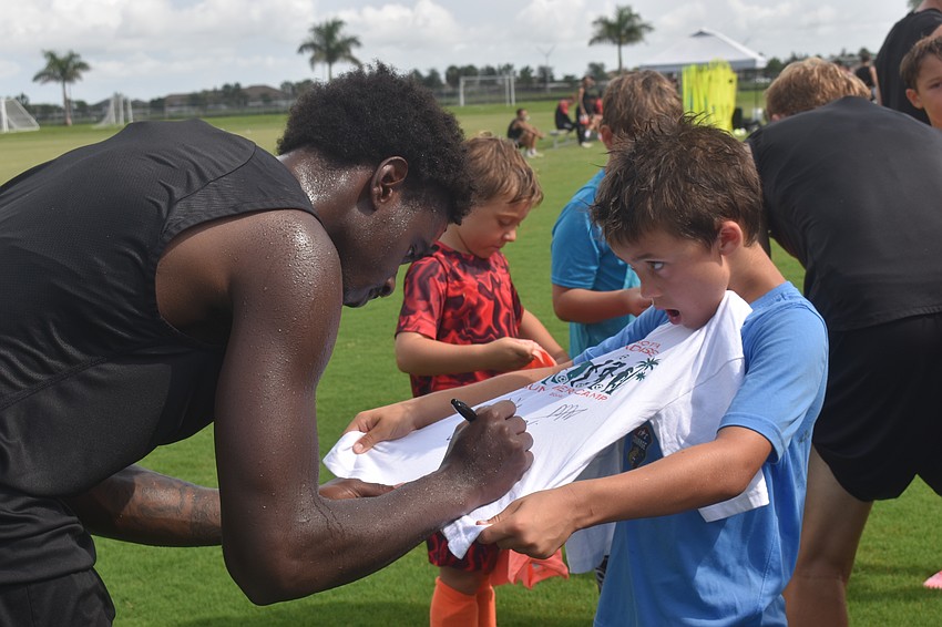 Sarasota Paradise forward Sean Karani signs a shirt for camper Josh Robert, who hopes to also be a pro someday.