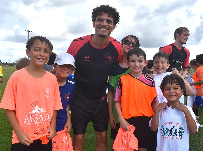 Sarasota Paradise player Roberto Burlew (center) poses for a photo with the campers.