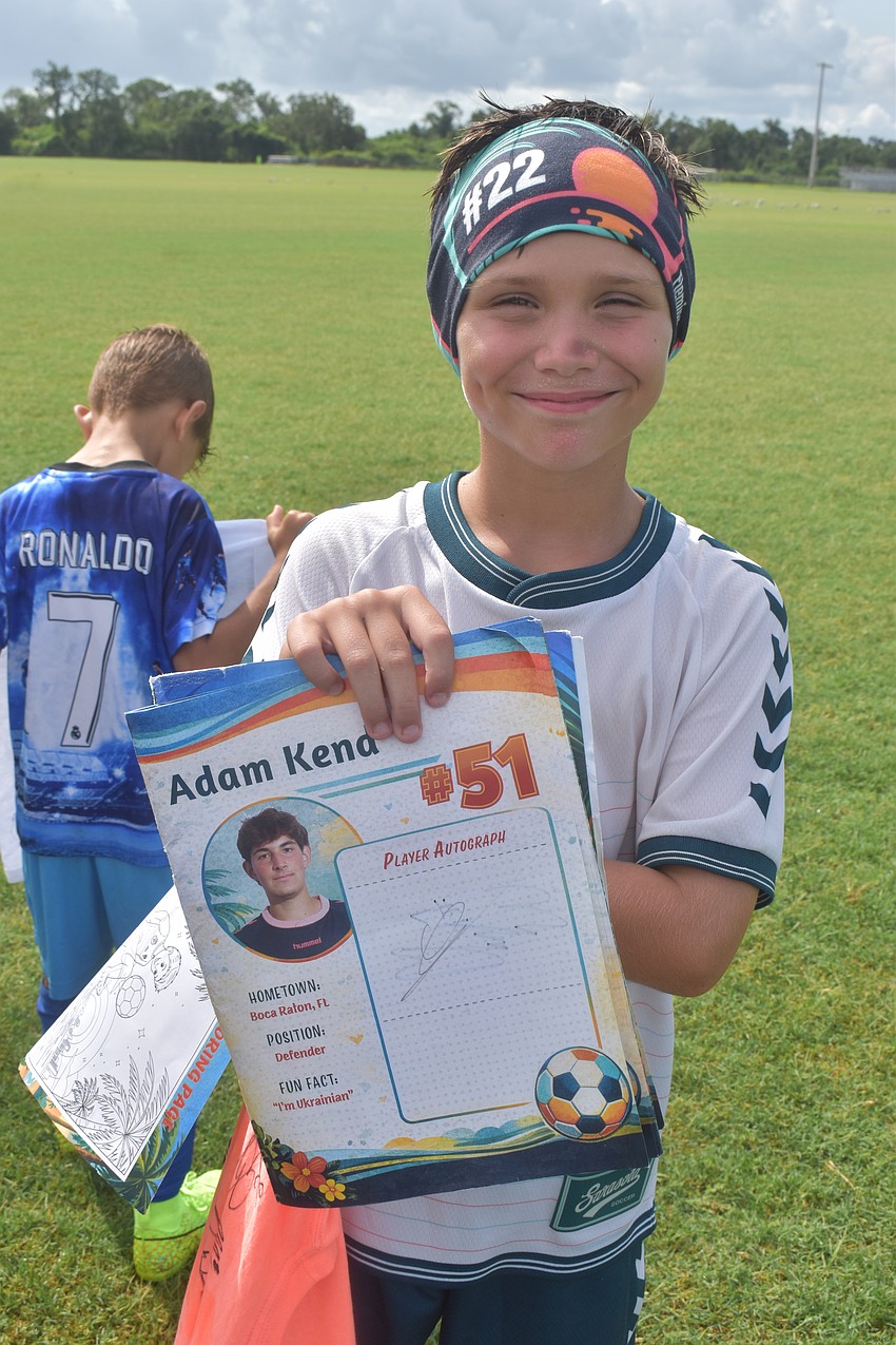 Bradenton 9-year-old Jakob Fleming, a super fan of the Sarasota Paradise, gets his program signed by the players.