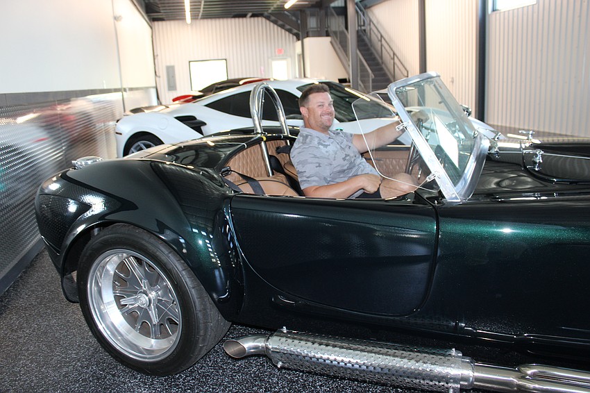 Prestige Auto Experiences owner Jeremy Keller sits in a prized 1965 Shelby Cobra replica.