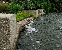 Waves lap against the weathered Bayfront Park seawall, which was installed before the town acquired the land to expand the park in 2011.