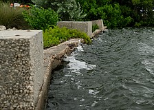 Waves lap against the weathered Bayfront Park seawall, which was installed before the town acquired the land to expand the park in 2011.