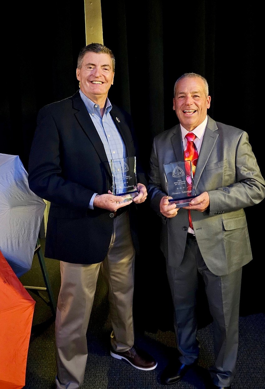 Vinny O'Shaughnessy, left, and Tom Tatarian accept awards for “Comeback Runner of the Year” and “Runner of the Year” respectively from the local track club.