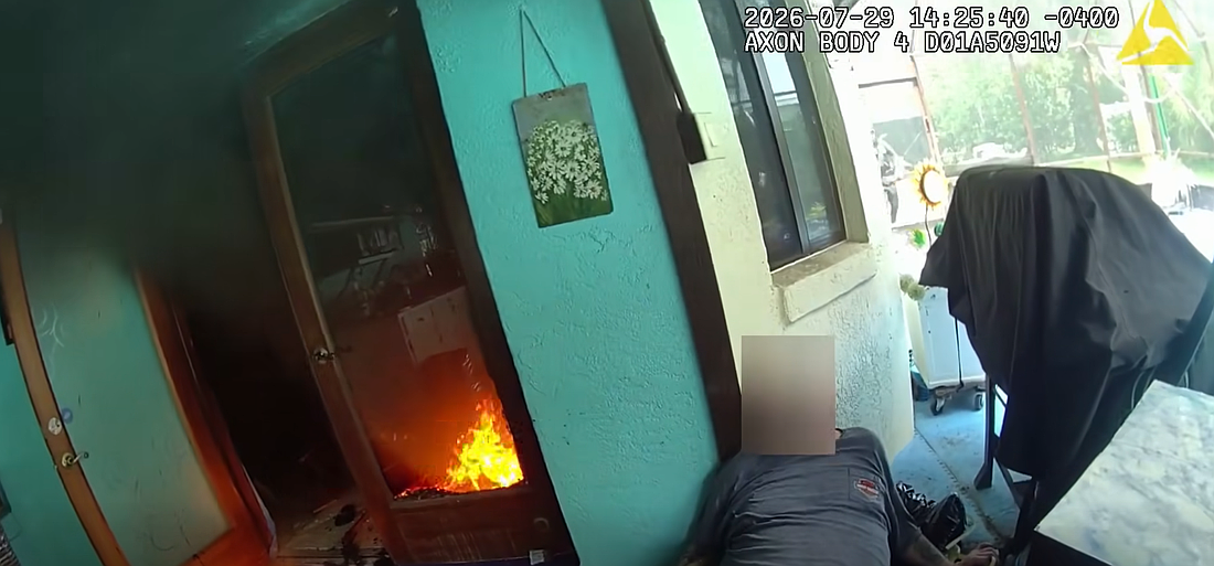 A Flagler County Sheriff's Office deputy locates a homeowner trapped on a rear patio just feet from flames. Screenshot