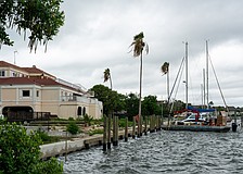 Workers install boat slips behind the vacant lot where the Buccaneer Restaurant is planned. Additional slips will be installed behind the Harbor Square office building pictured left.