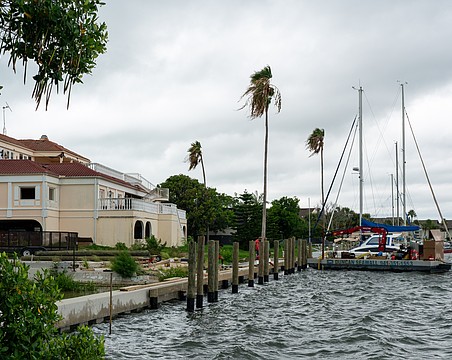 Workers install boat slips behind the vacant lot where the Buccaneer Restaurant is planned. Additional slips will be installed behind the Harbor Square office building pictured left.