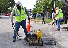 Willie Blackwood, Manatee County Public Works maintenance technician, repairs one of thousands of potholes that Manatee County needs to fill every year. Commissioner George Kruse wants transportation reserves released so the county can catch up on road repairs.