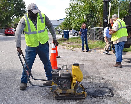 Willie Blackwood, Manatee County Public Works maintenance technician, repairs one of thousands of potholes that Manatee County needs to fill every year. Commissioner George Kruse wants transportation reserves released so the county can catch up on road repairs.