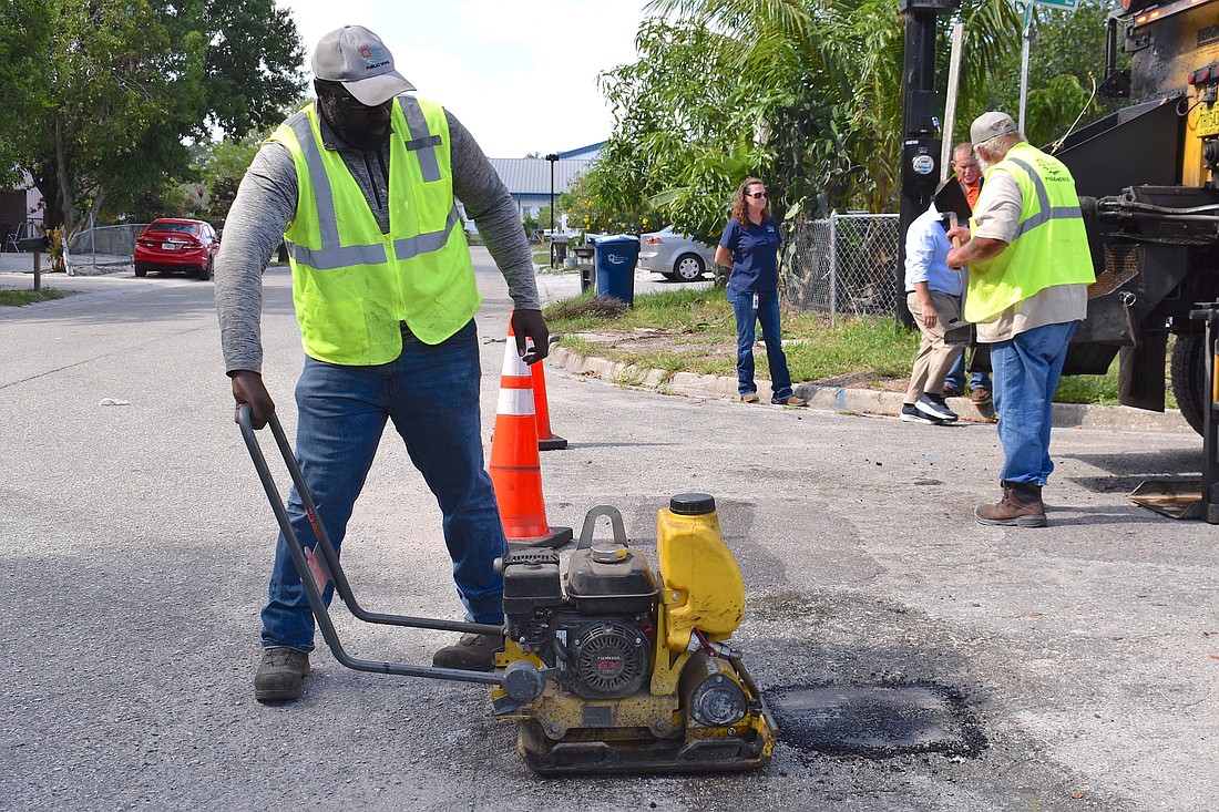 Willie Blackwood, Manatee County Public Works maintenance technician, repairs one of thousands of potholes that Manatee County needs to fill every year. Commissioner George Kruse wants transportation reserves released so the county can catch up on road repairs.