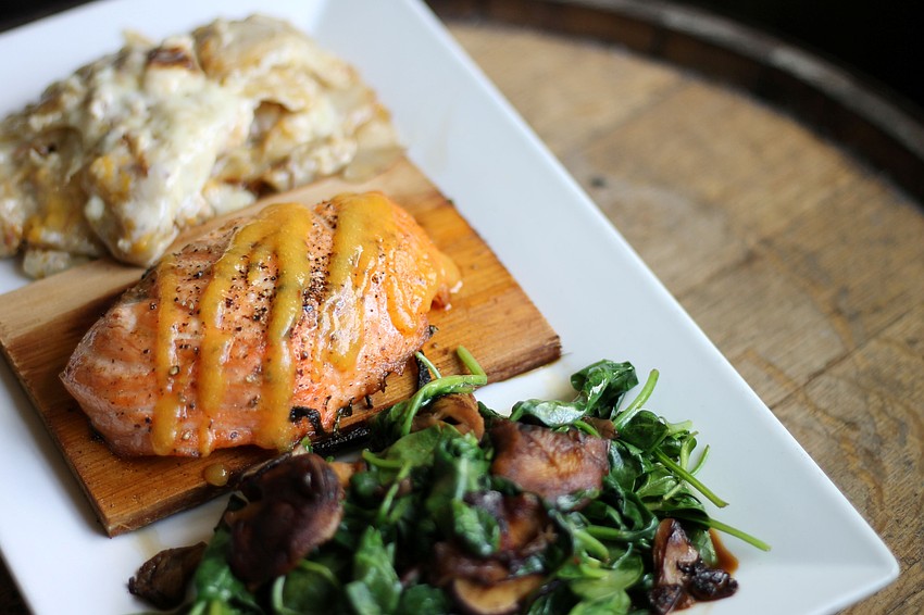 Boca Ciega Waterfront Bar & Grill’s Cedar Plank Salmon features North Atlantic salmon with a mango chipotle glaze, served with au gratin potatoes, wilted spinach and wild mushrooms.