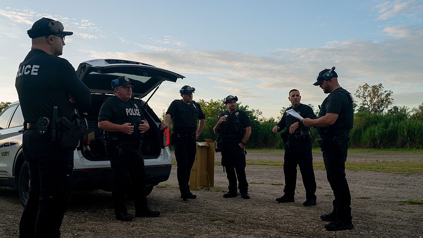 Longboat Key police officer Gregg Pescuma (right) reviews policies and gives instructions before LKPD officers perform state-mandated annual firearm training in rural Manatee County Thursday, Aug. 6.
