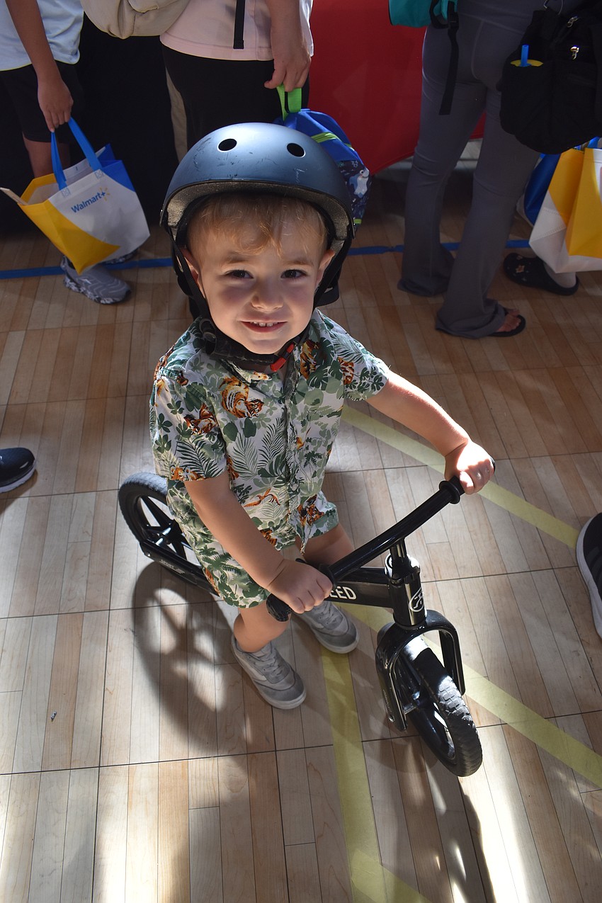 Harrison Guidie, 2, waits on wheels in the line for supplies and backpacks.