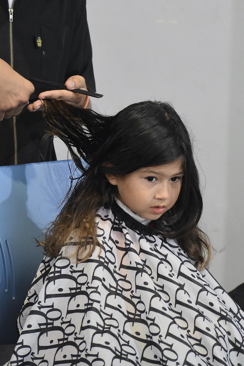 Janessa Delgadillo, 5, gets a haircut as she prepares to return to school.