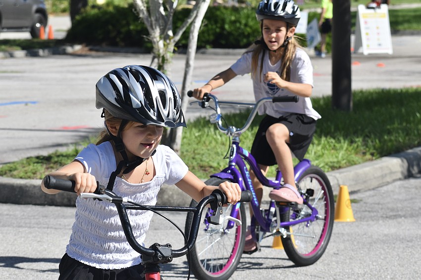 Charlotte Vovkulin, 6, and her sister Elise Vovkulin, 7, ride on the Sarasota BMX course.