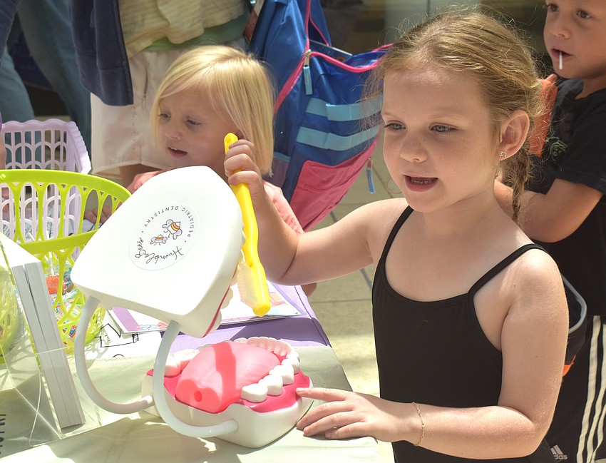 Bradenton 5-year-old Emma Wisniewski says she wants to be a dentist after brushing some abnormally large teeth at the HumbleBees Pediatric Dentistry booth at the Back to School Bash.