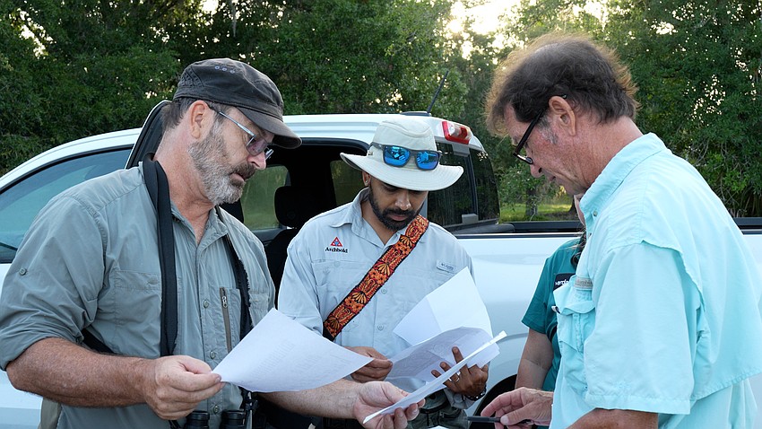 Biologists Raoul Boughton, Sahas Barve and Todd Mecklenborg work together to introduce 48 new Florida scrub-jays to Wingate Creek State Park in Myakka City.