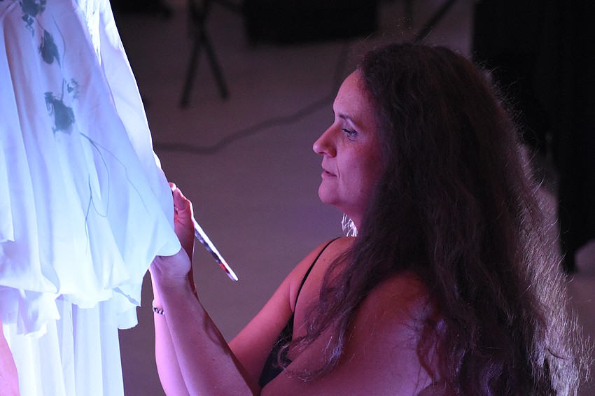 Sarasota's Natalia Logvinova paints the garments of Sarasota's Yuliya Suvalava, a living sculpture.
