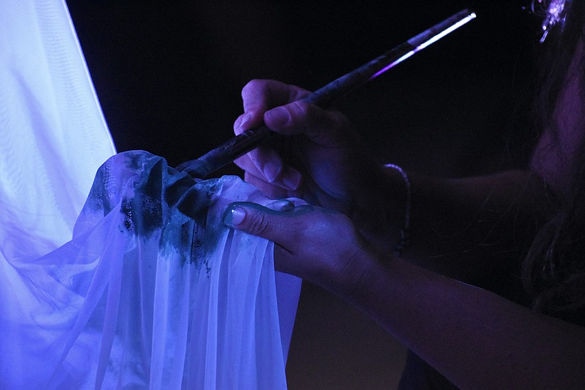 Sarasota's Natalia Logvinova paints the garments of Sarasota's Yuliya Suvalava, a living sculpture.