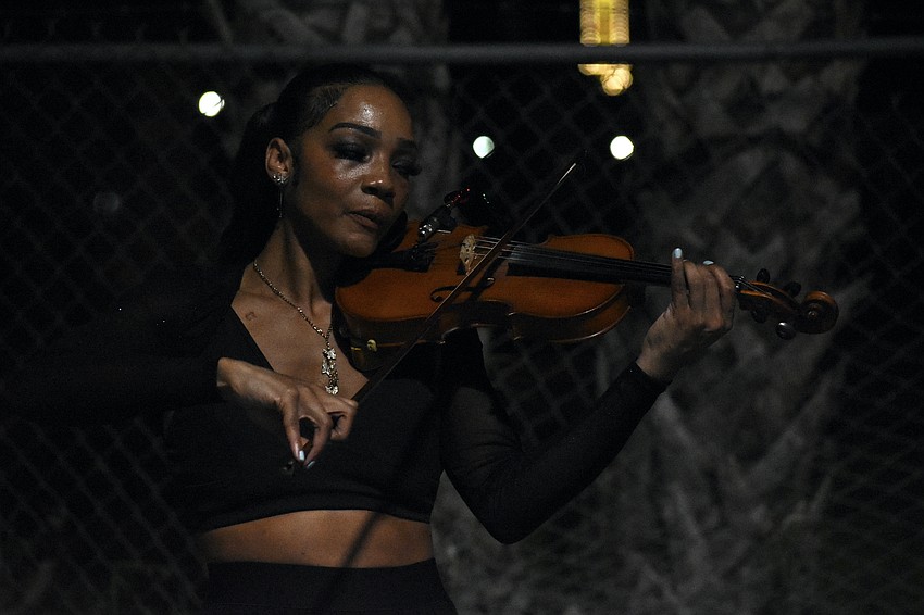 Violinist Candice Anderson accompanies the performance of St. Pete aerialist, fire performer and artist Mala Vavourakis.