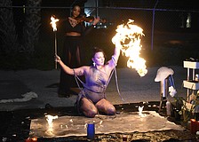 St. Pete aerialist, fire performer and artist Mala Vavourakis prepares to light up the canvas as violinist Candice Anderson performs behind her.