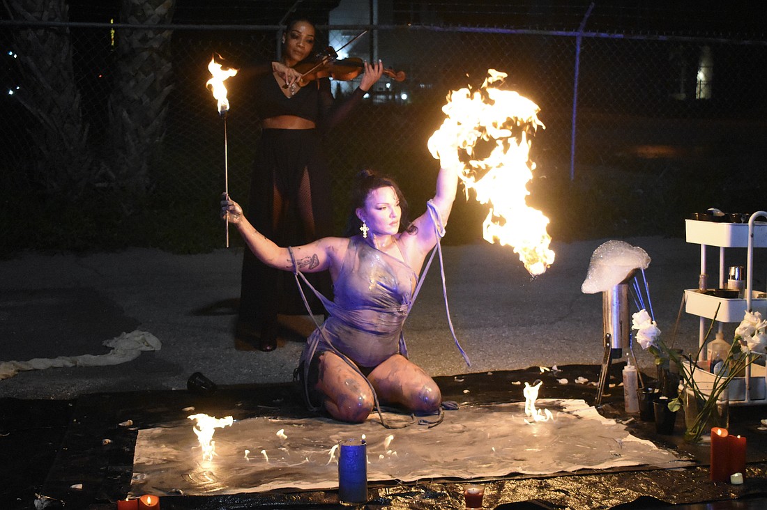 St. Pete aerialist, fire performer and artist Mala Vavourakis prepares to light up the canvas as violinist Candice Anderson performs behind her.
