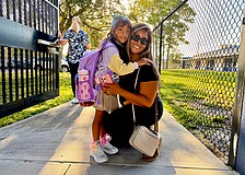 Official kindergartener Avalyn Chavez, 5, hugs Ruby Chavez at the gate of Alta Vista Elementary School on Aug. 10. In an interview, Avalyn said she was excited to meet her teacher and wear her new sparkling shoes for the first day of school.