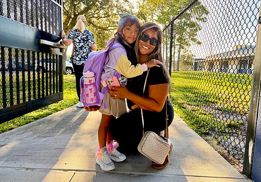 Official kindergartener Avalyn Chavez, 5, hugs Ruby Chavez at the gate of Alta Vista Elementary School on Aug. 10. In an interview, Avalyn said she was excited to meet her teacher and wear her new sparkling shoes for the first day of school.