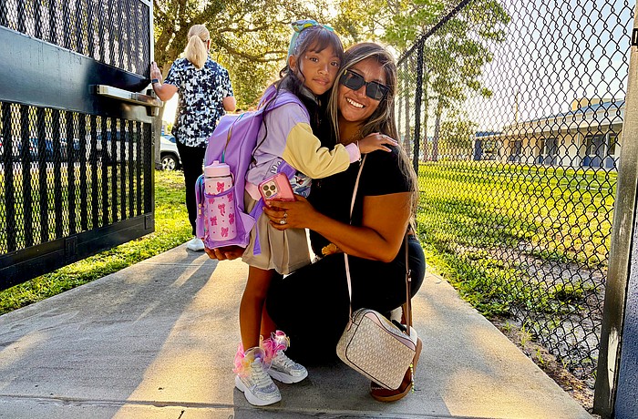 Official kindergartner Avalyn Chavez, 5, hugs Ruby Chavez at the gate of Alta Vista Elementary School on Aug. 10. In an interview, Avalyn said she was excited to meet her teacher and wear her new sparkling shoes for the first day of school.