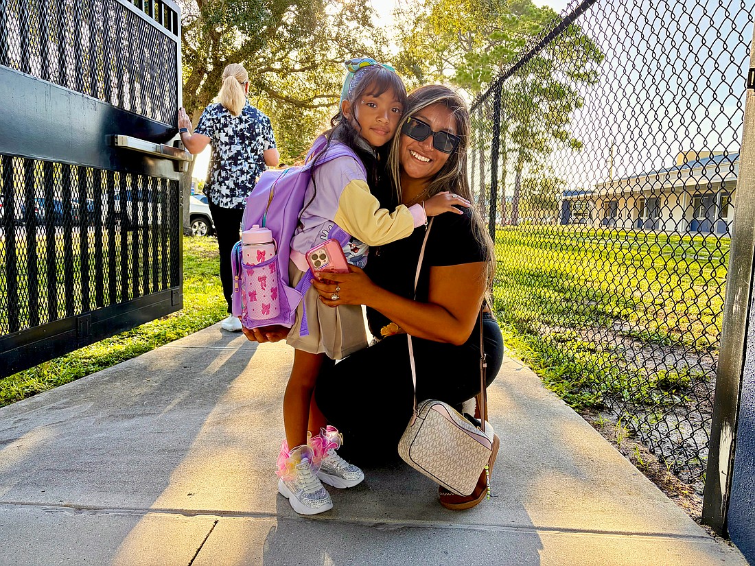Official kindergartener Avalyn Chavez, 5, hugs Ruby Chavez at the gate of Alta Vista Elementary School on Aug. 10. In an interview, Avalyn said she was excited to meet her teacher and wear her new sparkling shoes for the first day of school.