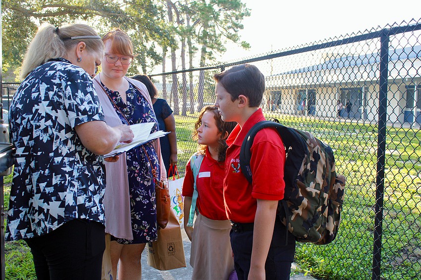 Wyatt and Lillian Hill, respectively entering the 5th and 3rd grade, sign in at Alta Vista Elementary School for the first day of school on Monday before Priscilla Hill sees them to their classrooms.