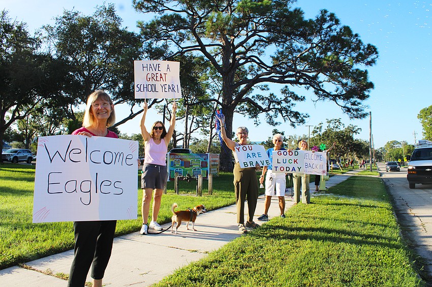 As has become tradition, members of the First Congregational United Church of Christ located across the street from Alta Vista Elementary School hold up signs with words of encouragement for the students heading off to their first day of school.