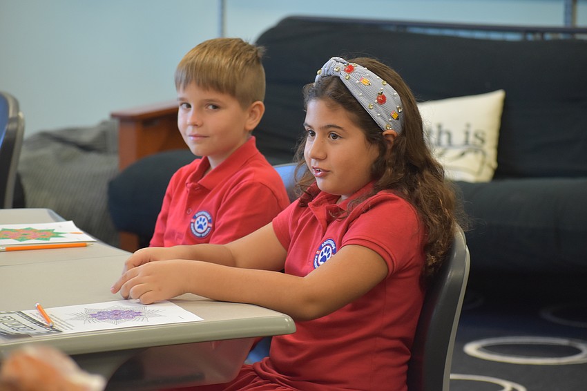 Beatrice Stathis and Makar Khartikov listen as students say hello by discussing their 