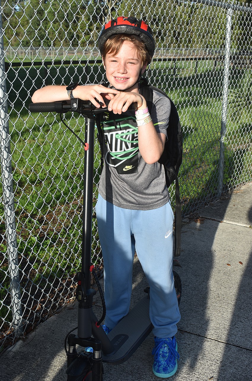 Fifth grader Parker Chrisman rides to school in style, but also safely with a helmet, on his first day of school at McNeal Elementary.