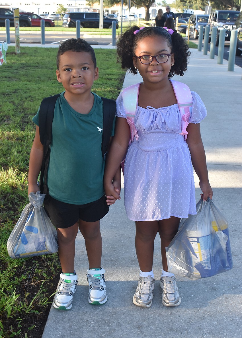 First grader Sapphire Howard (right) is happy and proud to walk her brother, Silas Howard, into McNeal Elementary for his first day of kindergarten.