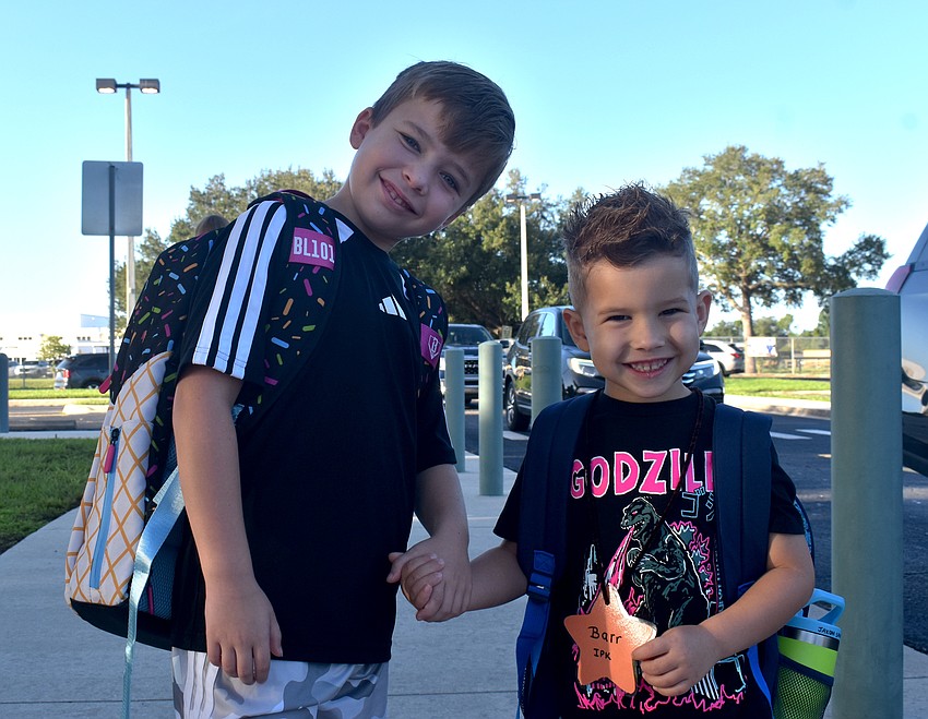 Third grader Kayden Sandlin and his younger brother, prekindergarten student Jaxon Sandlin, walk hand in hand into McNeal Elementary for their first day Aug. 10.