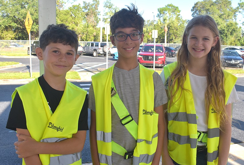 Fourth grader Leo Rivera and fifth graders Matteo Saviano and Avery Scherzer are among the 24 member Safety Patrol that help younger students get out of their cars in the car line.