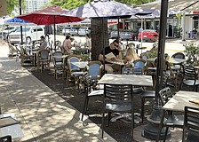 Diners have lunch at one of the restaurants offering street-side seating on Main Street.