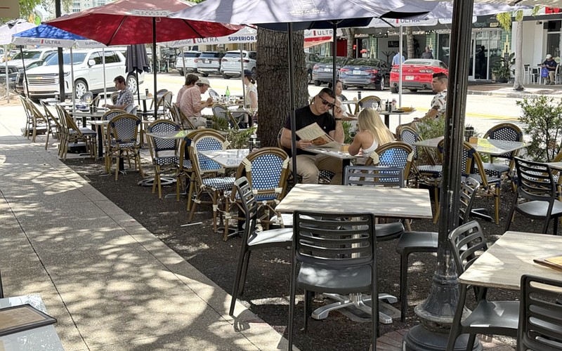 Diners have lunch at one of the restaurants offering street-side seating on Main Street.