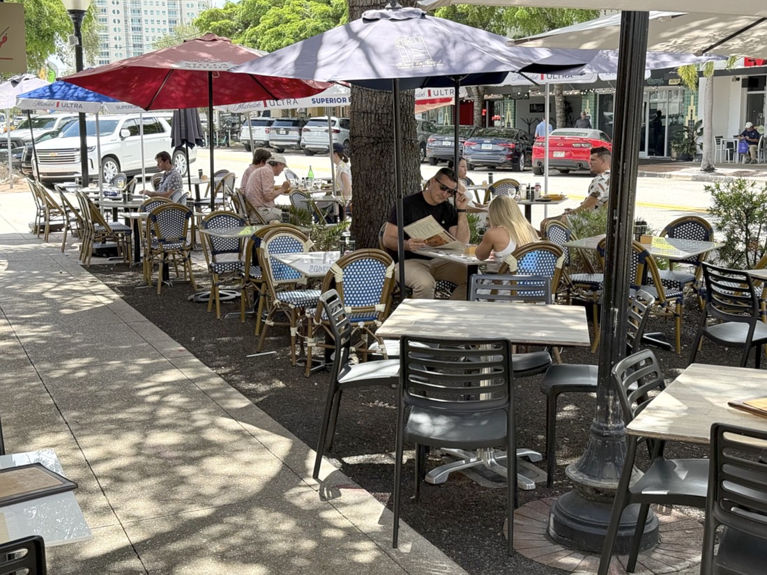 Diners have lunch at one of the restaurants offering street-side seating on Main Street.