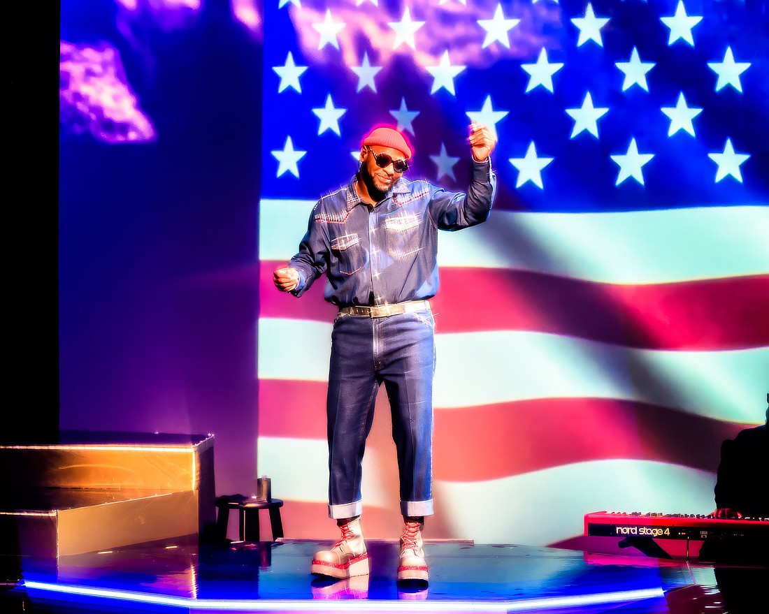Westcoast Black Theatre Troupe's Sheldon Rhoden stands in front of an image of the American flag as he sings Marvin Gaye's rendition of "The Star Spangled Banner."